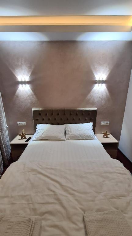 sypialnia z dużym białym łóżkiem z 2 stolikami nocnymi w obiekcie Studio Albert w mieście Râmnicu Vâlcea
