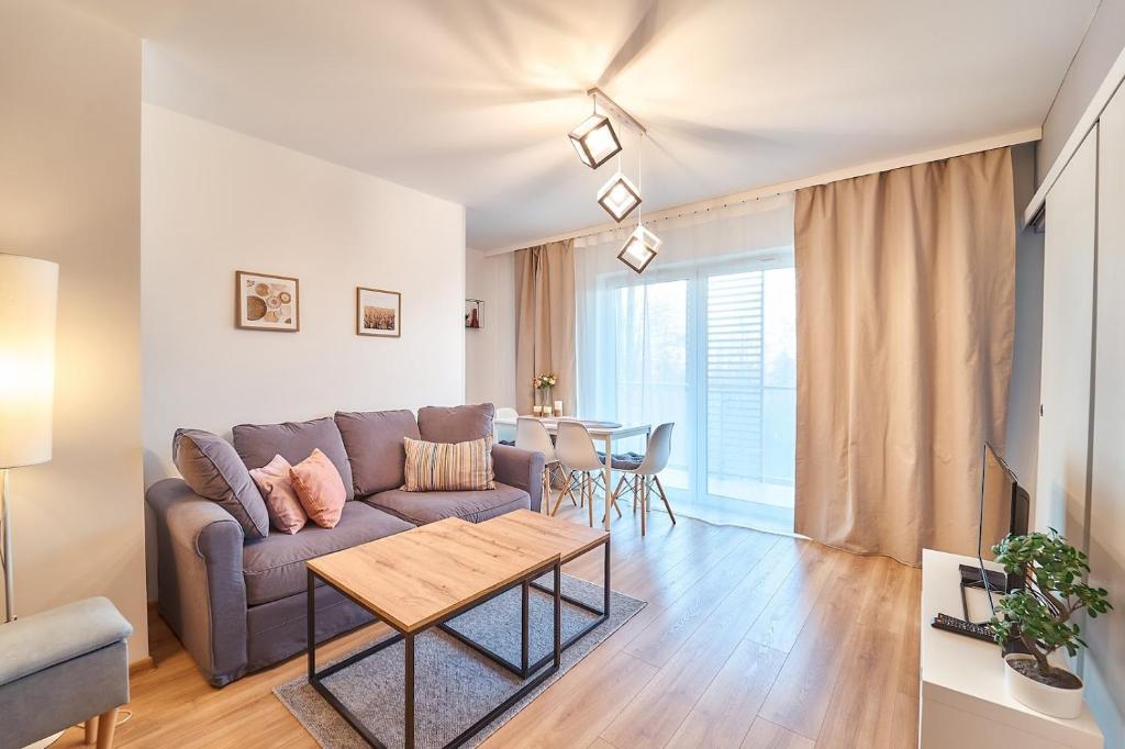 a living room with a couch and a table at LAGUNA Apartament Polanica Residence 21 in Polanica-Zdrój