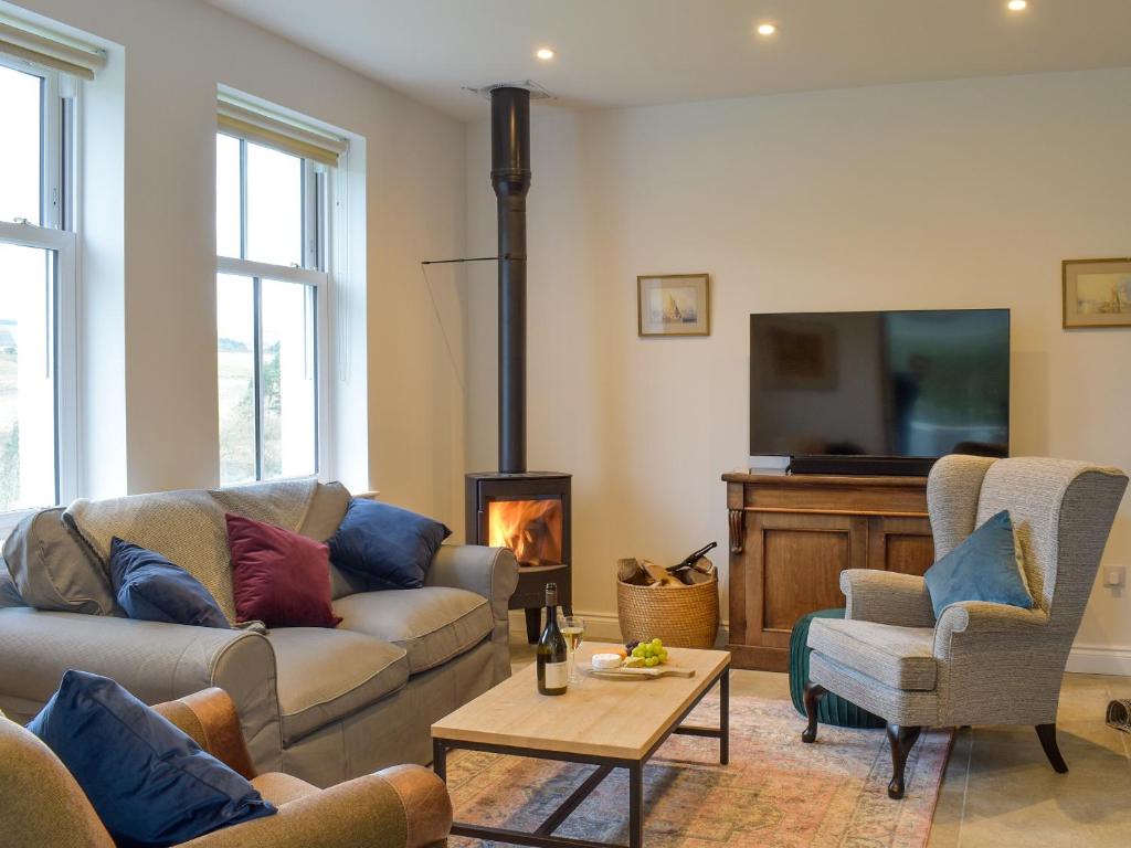 a living room with a couch and a fire place at Tweedford Cottage-uk41063 in Drummelzier