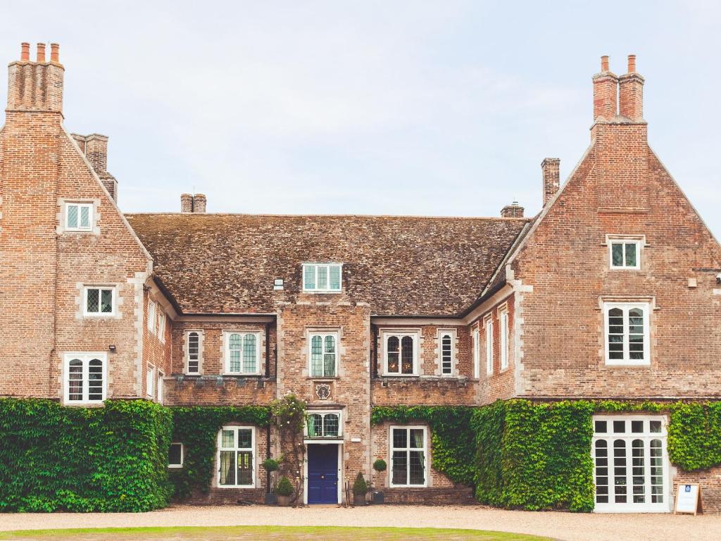 an old brick house with ivy on it at Hockwold Hall in Hockwold cum Wilton