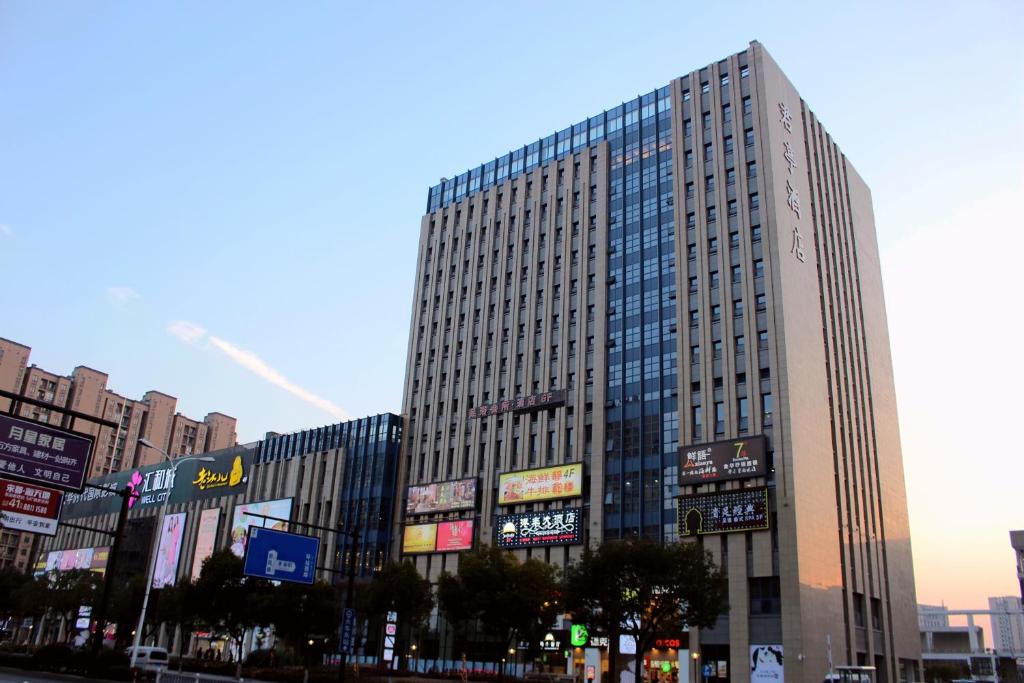 un edificio alto con muchas señales en una ciudad en SSAW Boutique Hotel Hangzhou East en Hangzhou