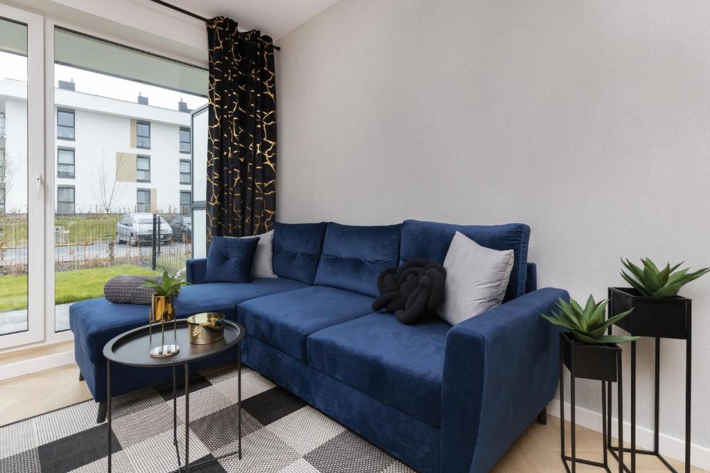 a living room with a blue couch and a table at Apartments Beaufort Estate by Renters in Gdynia