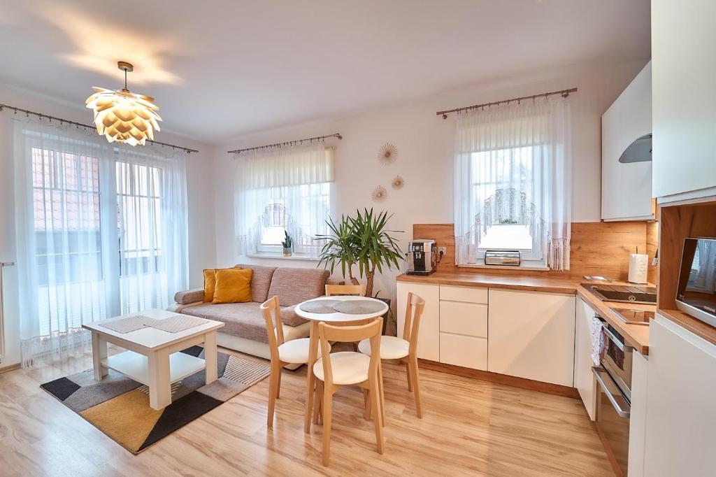 a kitchen and living room with a couch and a table at Apartament Willa Ogrodowa 18 in Polanica-Zdrój