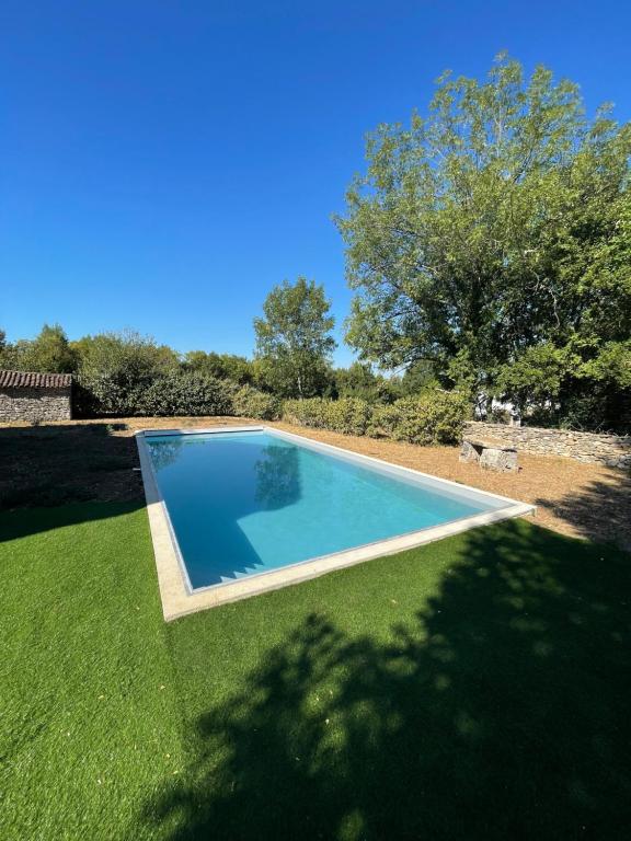 a swimming pool in a yard with green grass at Maison piscine Lot in Laburgade