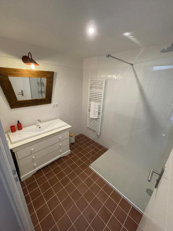 a bathroom with a shower and a sink and a mirror at Maison piscine Lot in Laburgade