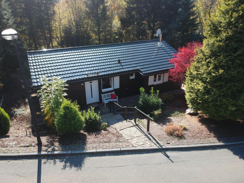 a small house with a porch and some bushes at Chalet Heide in Winterberg