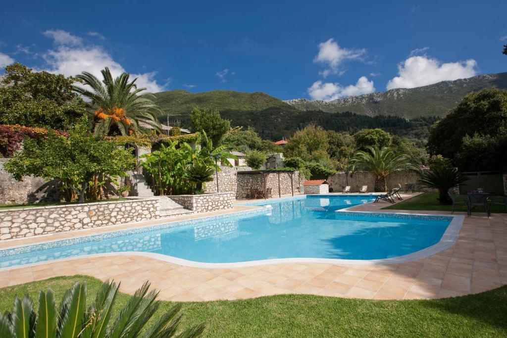 - une piscine dans un complexe avec des montagnes en arrière-plan dans l'établissement Villagio Magnolia, à Sívros