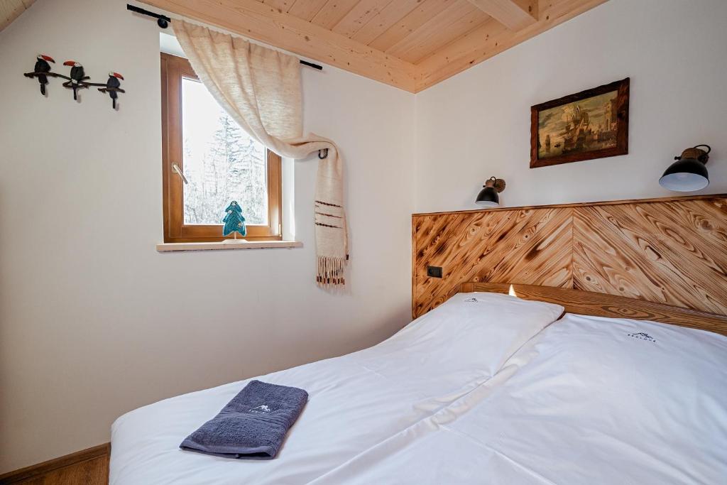 une chambre avec un lit blanc avec une fenêtre dans l'établissement Reglove luksusowe apartamenty, à Zakopane