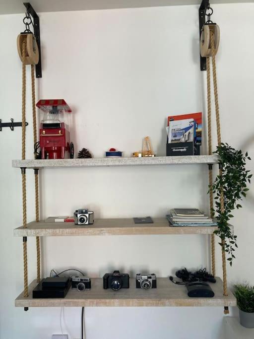 a shelf with cameras and other items on it at Appartement 1 chambre proximité Port de commerce et Gare SNCF in Brest