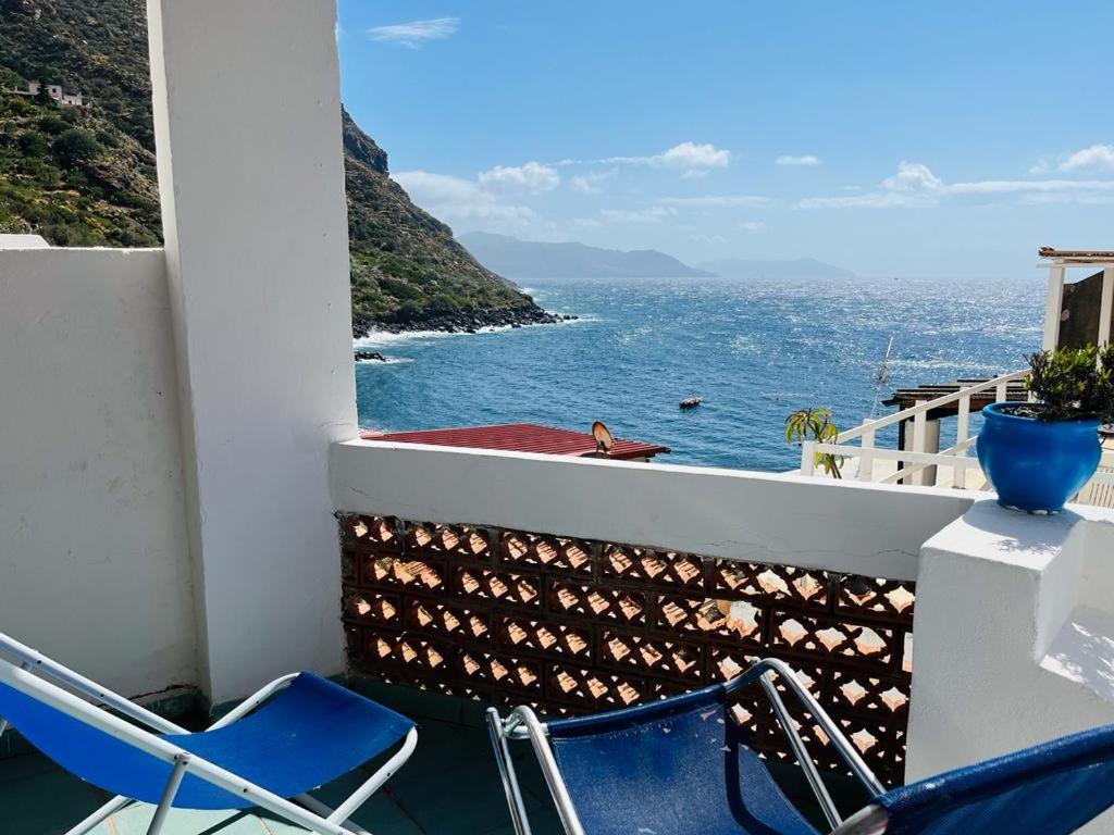 Dos sillas azules sentadas en un balcón con vistas al océano en Perla Salina, en Leni