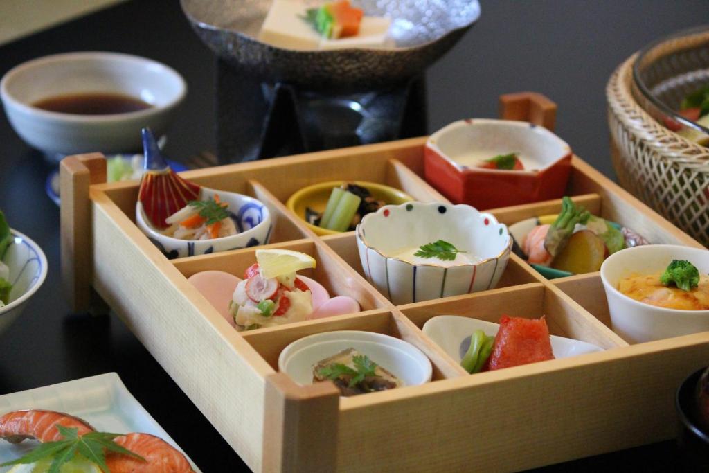 a wooden box filled with different types of sushi at Hotel Honnoji in Kyoto