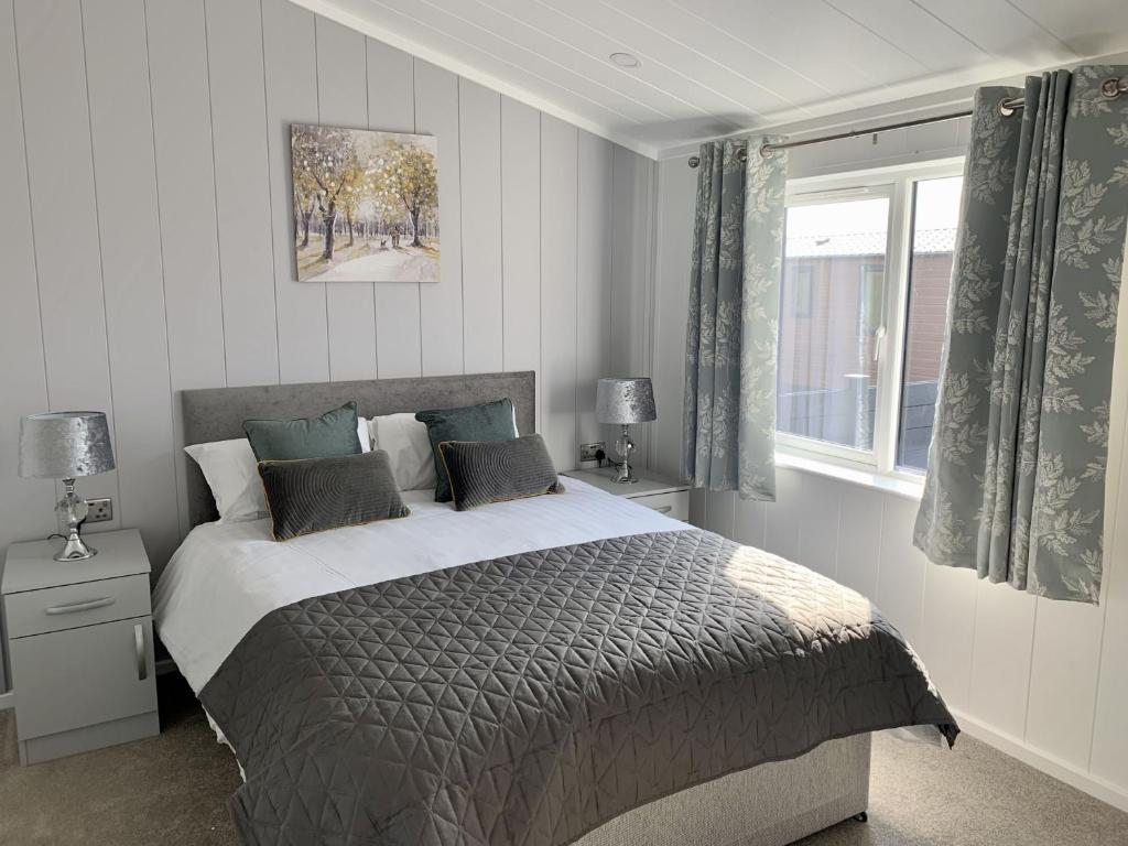 a bedroom with a large bed and a window at Cherry Blossom 43 Hot Tub in Garton