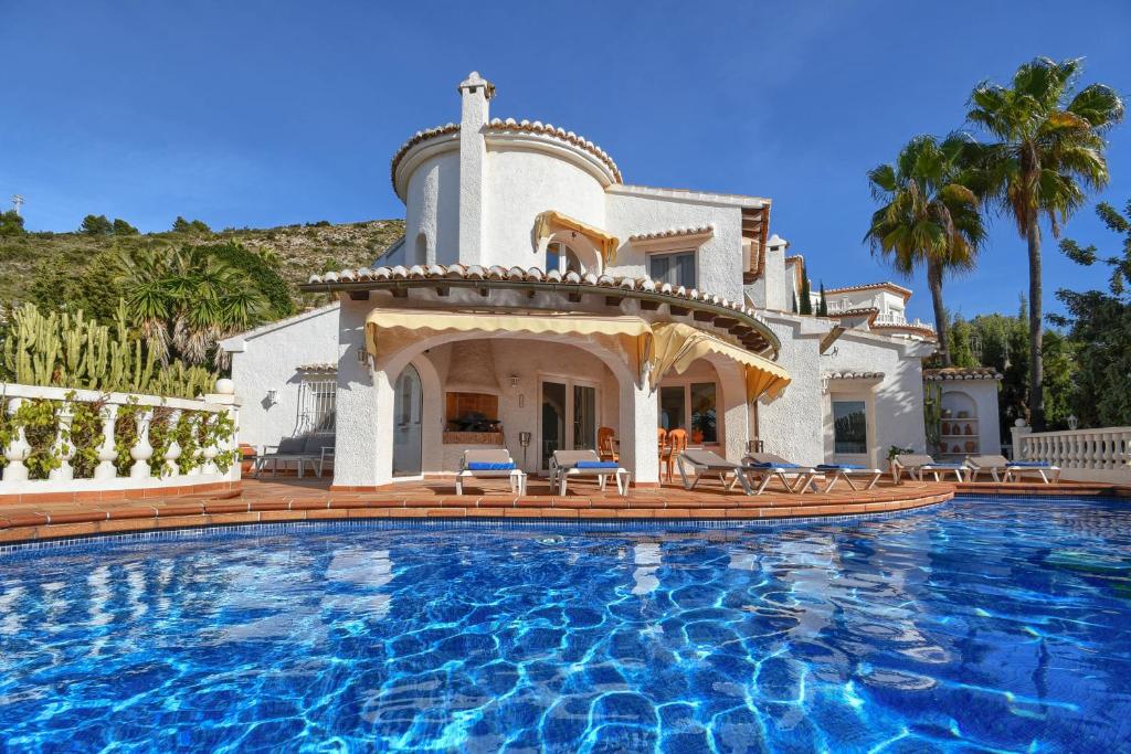 a villa with a swimming pool in front of a house at Casa Chimo in Moraira