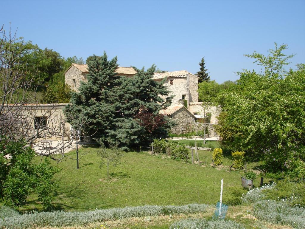an old stone house with a garden in the foreground at Domaine De La Grange Neuve in La Roque-sur-Pernes