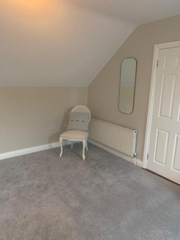 a white chair sitting in the corner of a room at The Mews in Newbridge