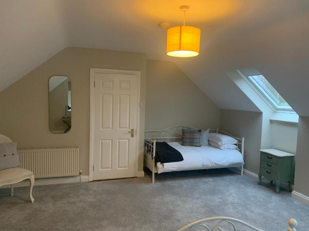 a bedroom with a bed and a window and a door at The Mews in Newbridge