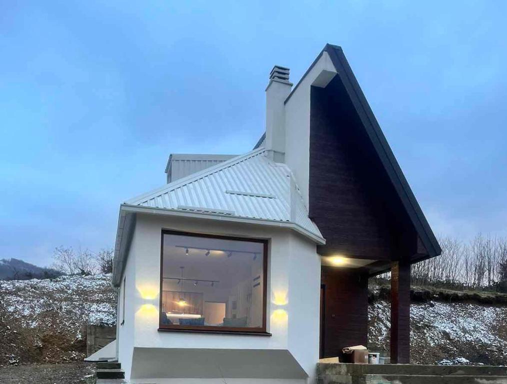 una piccola casa bianca con una grande finestra di Villa Luce a Kolašin