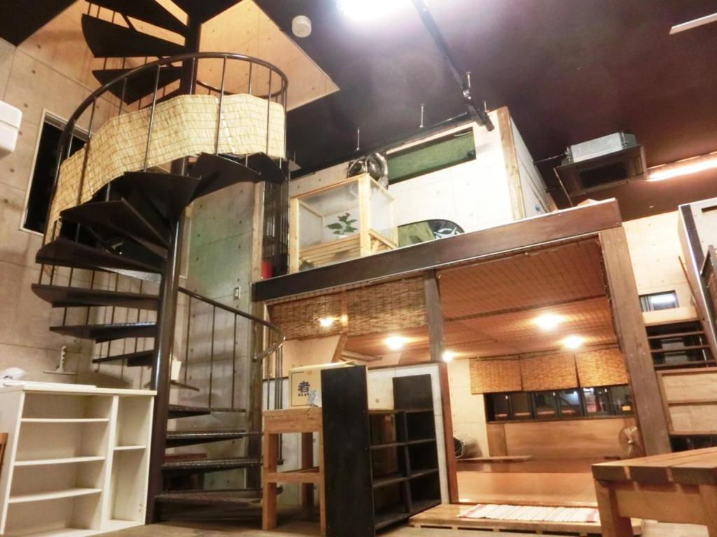 un edificio con una escalera de caracol en una habitación en 潮風room@SUN(シオカゼルームアットサン), en Chikura