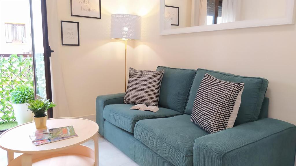 a living room with a blue couch and a table at Sherryflat Trébol - Parking in Jerez de la Frontera