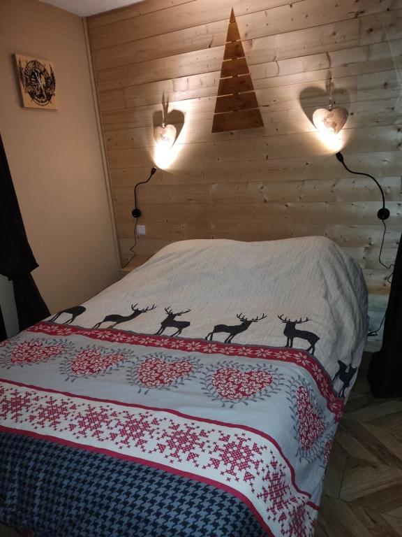 a bedroom with a bed with a blanket with deer on it at LES FONTANILLES odeillo chalet 60 WIFI & PARKING gratuit exposé plein sud & plein pied , draps & serviettes de toilettes non inclus, sabanas y toallas no incluidos in Font-Romeu-Odeillo-Via