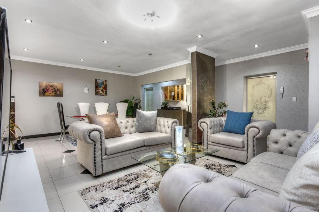 sala de estar con sofás y mesa en The Royal Residence, en Johannesburgo