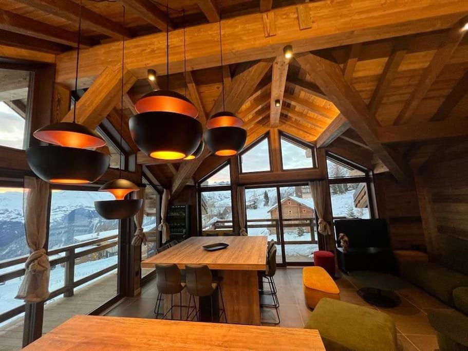 a large room with a table and some windows at Magnifique chalet sur les pistes, le Paradis c'est ici ! in La Toussuire