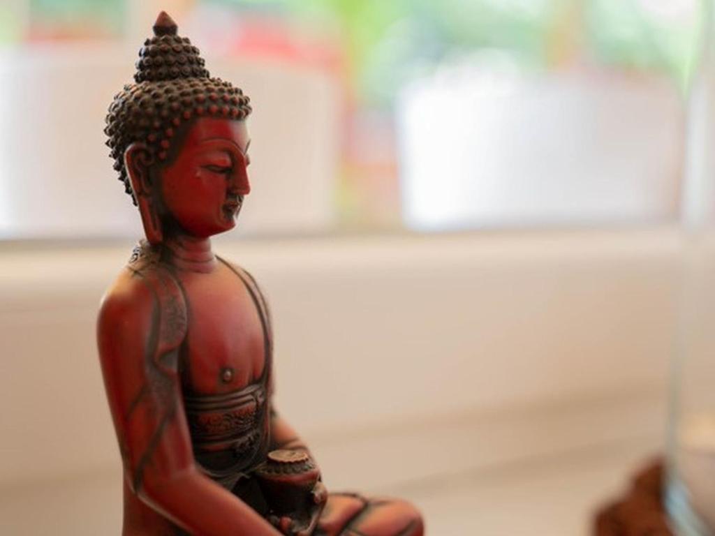 uma figura de um Buda sentado numa mesa em Yogahaus Prasaad em Engen