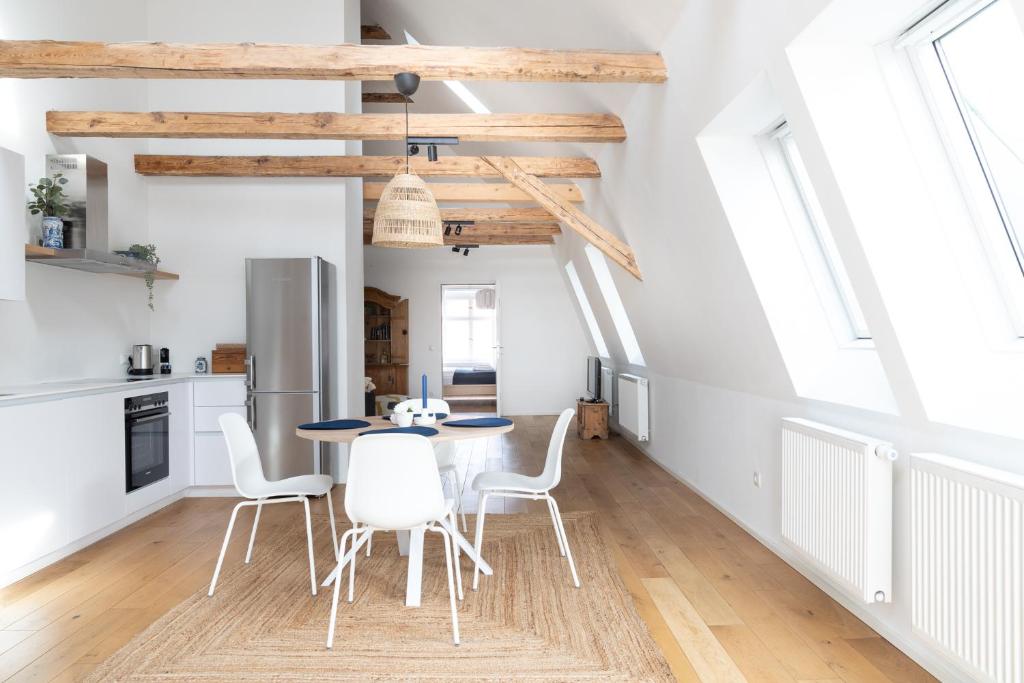 a kitchen and dining room with a table and chairs at Beautiful Penthouse - City Center in Graz