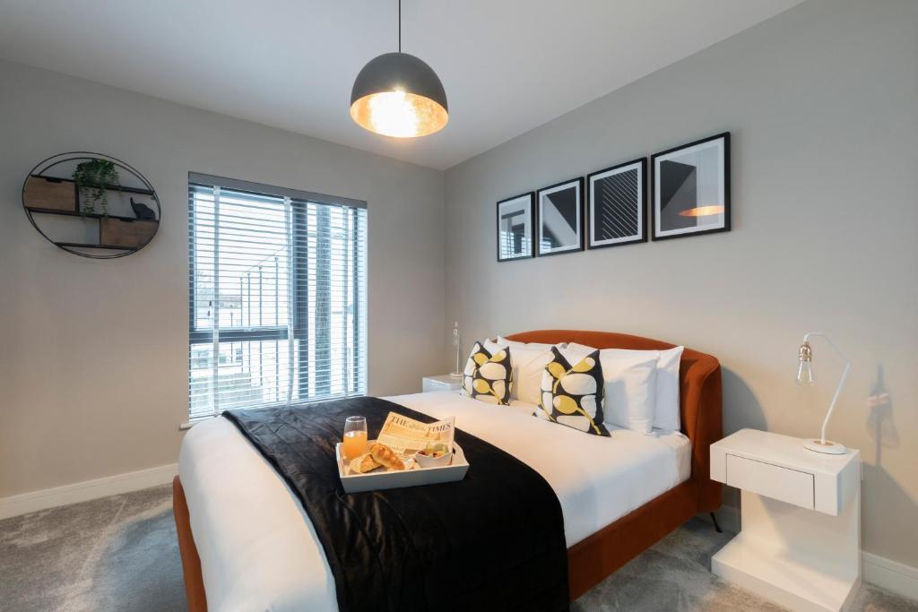 ein Schlafzimmer mit einem Bett, auf dem ein Tablett mit Essen steht in der Unterkunft Elliot Oliver - Chic 2 Bedroom Town Centre Apartment in Cheltenham
