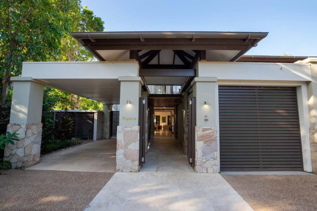 un garage avec une porte de garage dans une maison dans l'établissement NYARU Villa Port Douglas, QLD, à Port Douglas