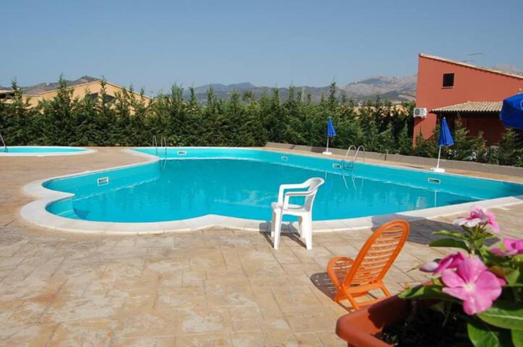 カンポフェリーチェ・ディ・ロッチェッラにあるVilla Limuti con piscina condominialeのスイミングプール(椅子2脚、テーブル付)
