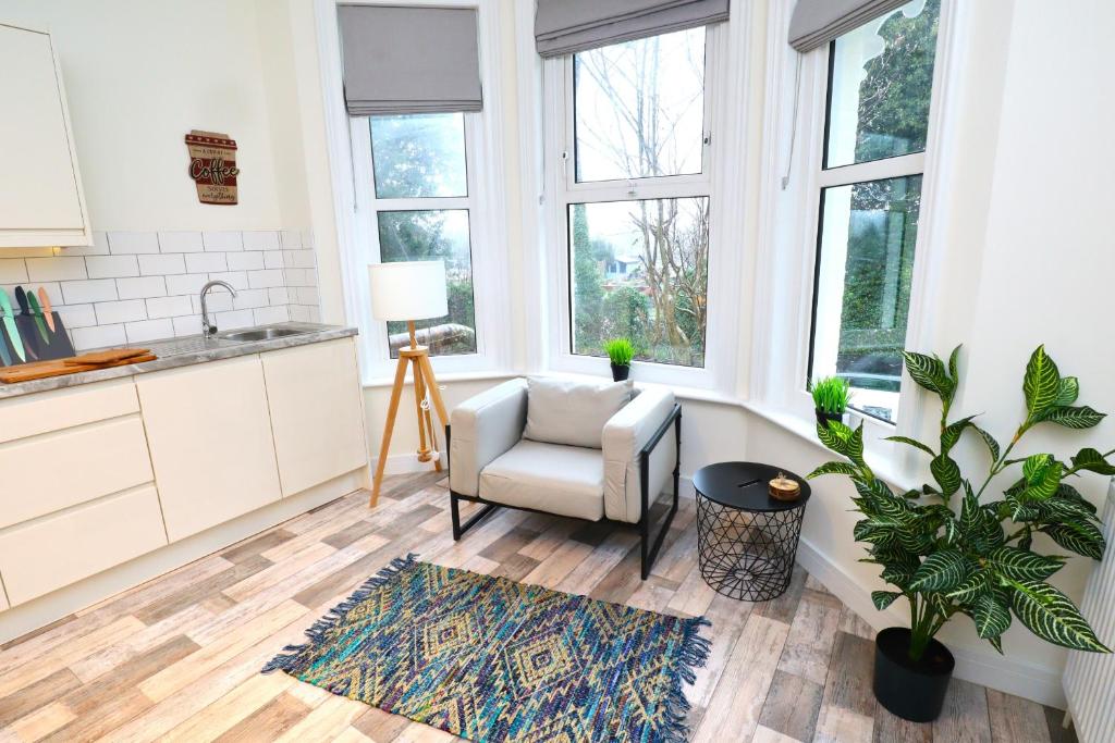 eine Küche mit einem Sofa, einem Stuhl und Fenstern in der Unterkunft The Lottbridge in Eastbourne