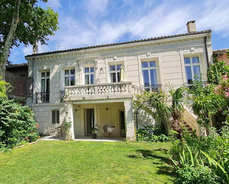 Cette grande maison blanche dispose d'un balcon et d'une cour. dans l'établissement Villa Aigarden maison d'hôtes, à Avignon