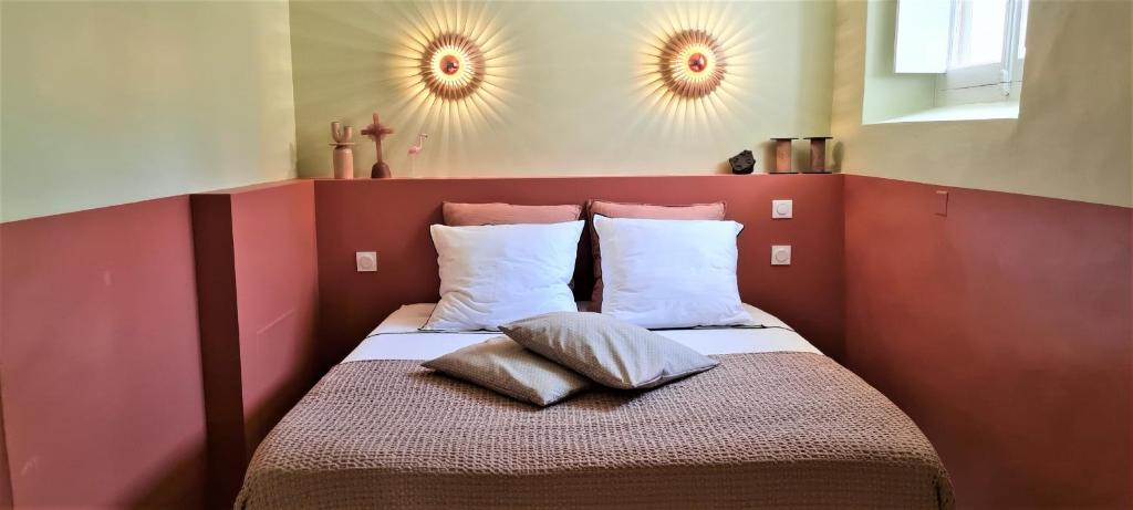ein Schlafzimmer mit einem Bett mit zwei Kissen darauf in der Unterkunft Villa Aigarden maison d&#39;hôtes in Avignon