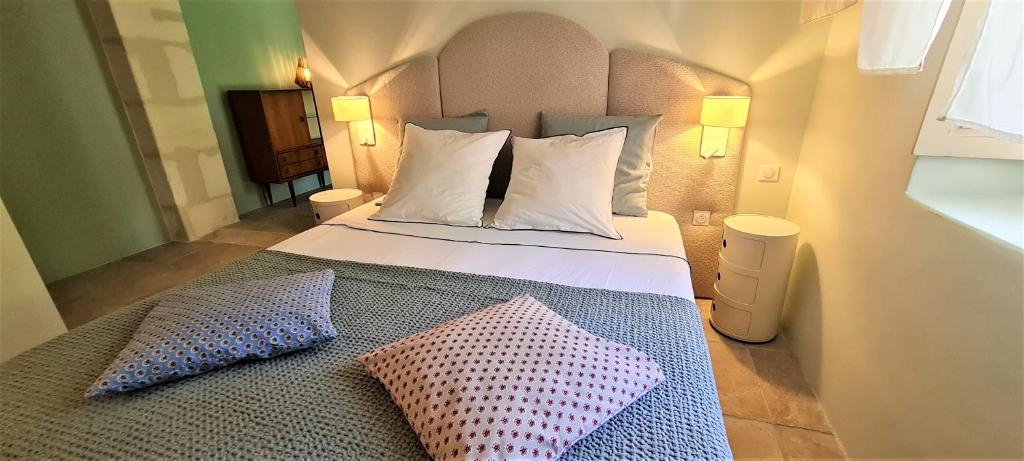 ein Schlafzimmer mit einem Bett mit zwei Kissen darauf in der Unterkunft Villa Aigarden maison d&#39;hôtes in Avignon
