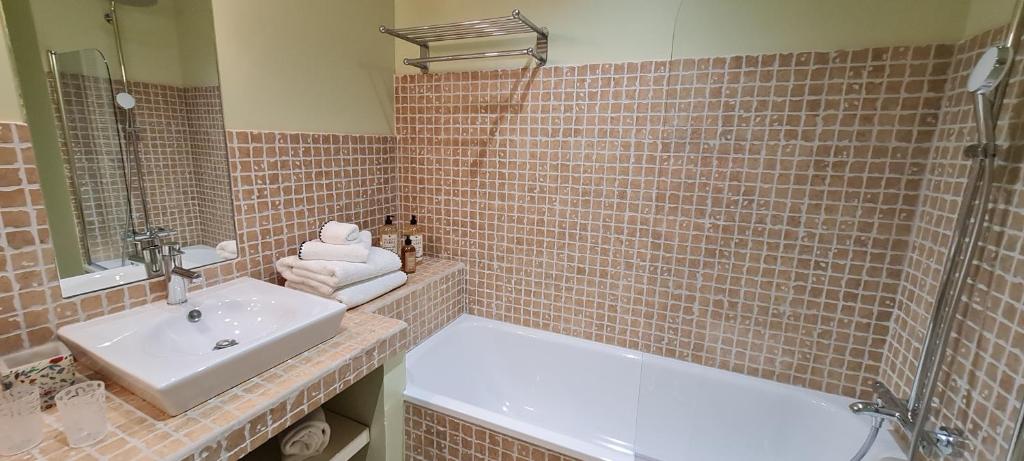 a bathroom with a sink and a tub and a shower at Villa Aigarden maison d'hôtes in Avignon