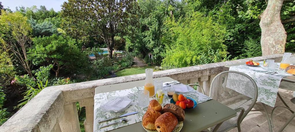 einen Tisch mit Brot und Obst auf dem Balkon in der Unterkunft Villa Aigarden maison d&#39;hôtes in Avignon