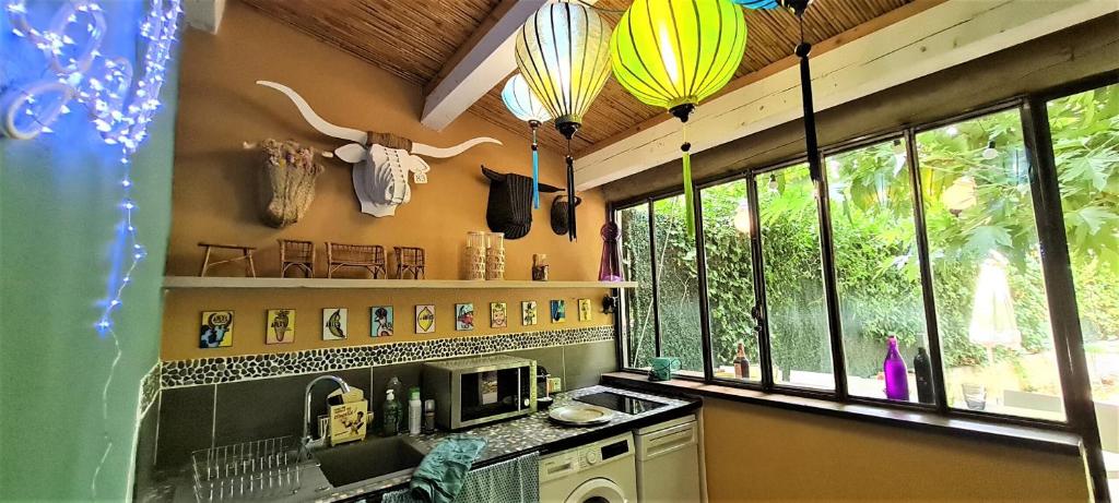 a kitchen with a sink and some windows at Villa Aigarden maison d'hôtes in Avignon