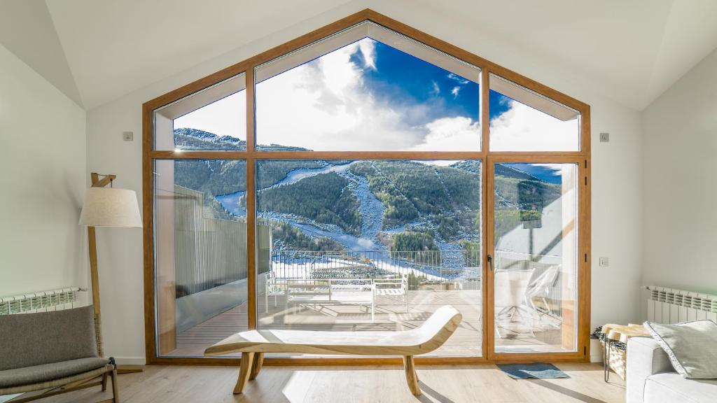 Habitación con ventana grande con vistas a la montaña. en KOKONO Luxury Ski Chalet Andorra, El Tarter, en El Tarter