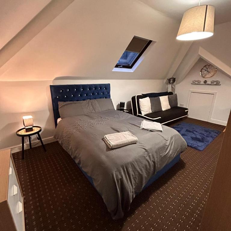 - une chambre avec un grand lit et une chaise dans l'établissement Bv Comfy Attic Studio At Deighton Huddersfield, à Huddersfield