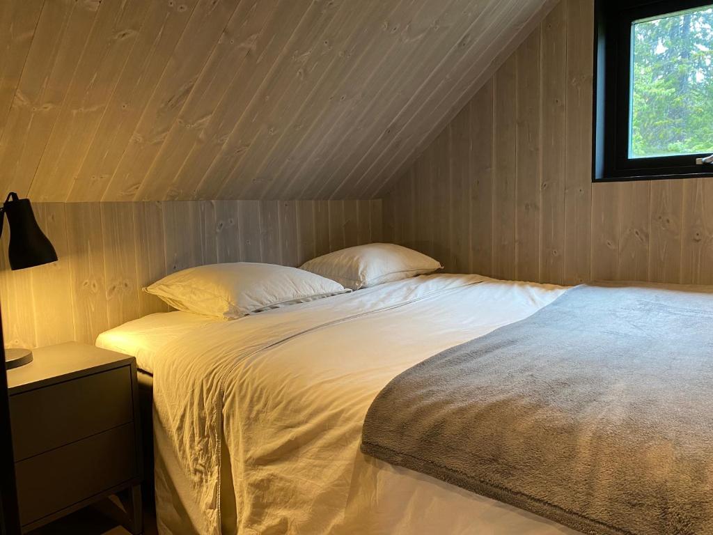 a bedroom with a large bed with a window at Nybyggd 8-bäddars skidstuga i Lofsdalen in Lofsdalen