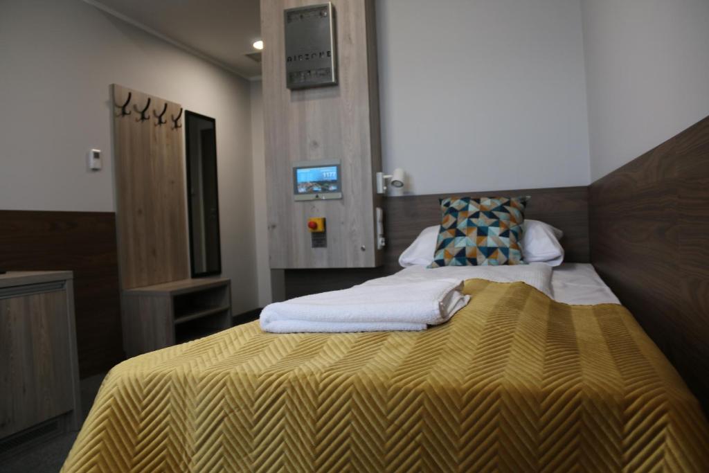 pokój hotelowy z 2 łóżkami i żółtym kocem w obiekcie Centralny Ośrodek Sportu - Spała w Spale