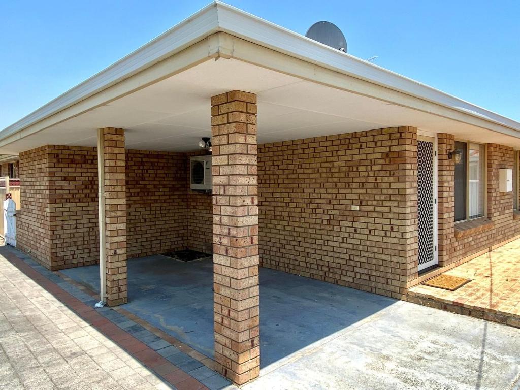 a brick house with a porch with a roof at Forrest Holiday Unit Bunbury in Glen Iris