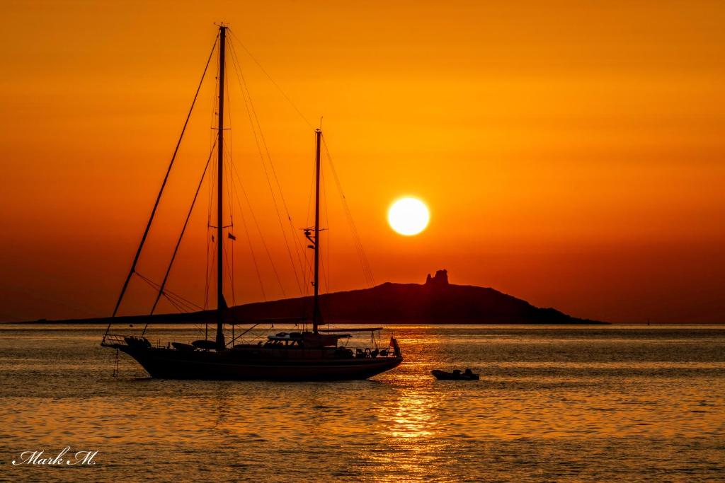 um veleiro na água ao pôr do sol em Ciuri Ciuri em Isola delle Femmine