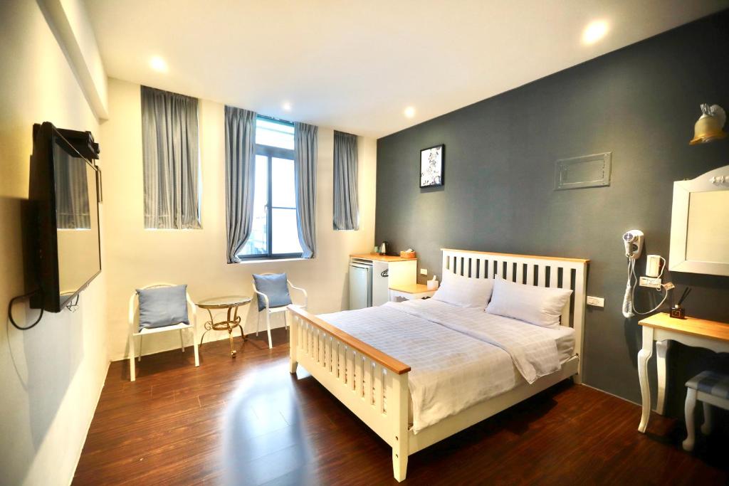 1 dormitorio con 1 cama, mesa y sillas en 好窩旅店, en Hengchun
