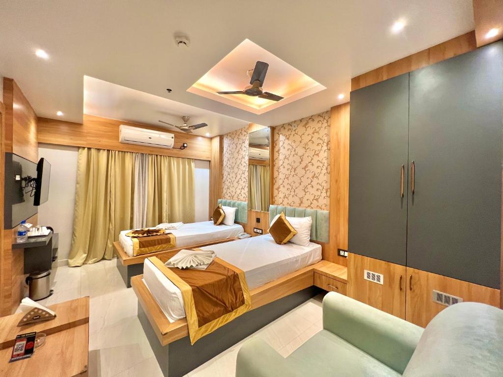 Habitación de hotel con 2 camas y sofá en THE MAGNUM, en Deoghar