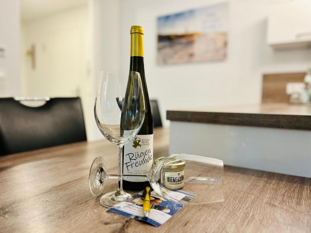 een fles wijn zittend op een tafel met een glas bij Ferienwohnung Meeresblick Haus Granitz in Prora in Binz
