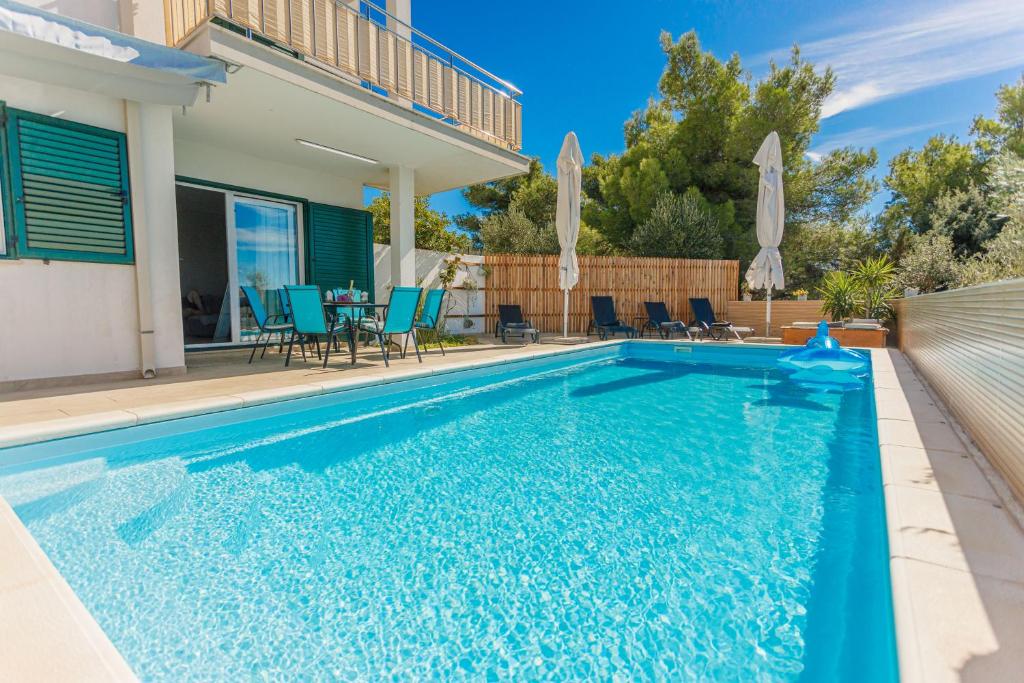 uma piscina com cadeiras e uma casa em Nono Jure , private pool & sauna em Milna
