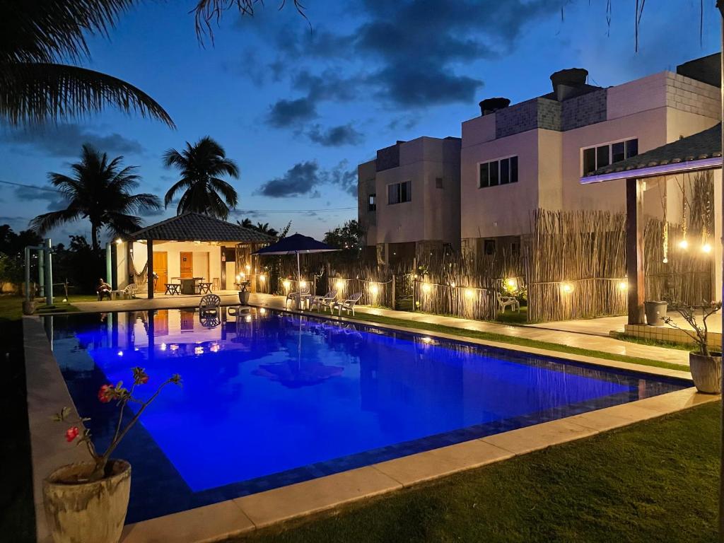 a swimming pool in front of a building at night at Reserva do Paiva suites in Cabo de Santo Agostinho