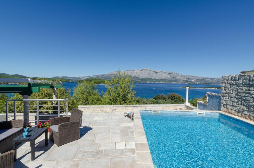 una piscina con vistas al agua en Traditional stone house with swimming pool, en Lumbarda